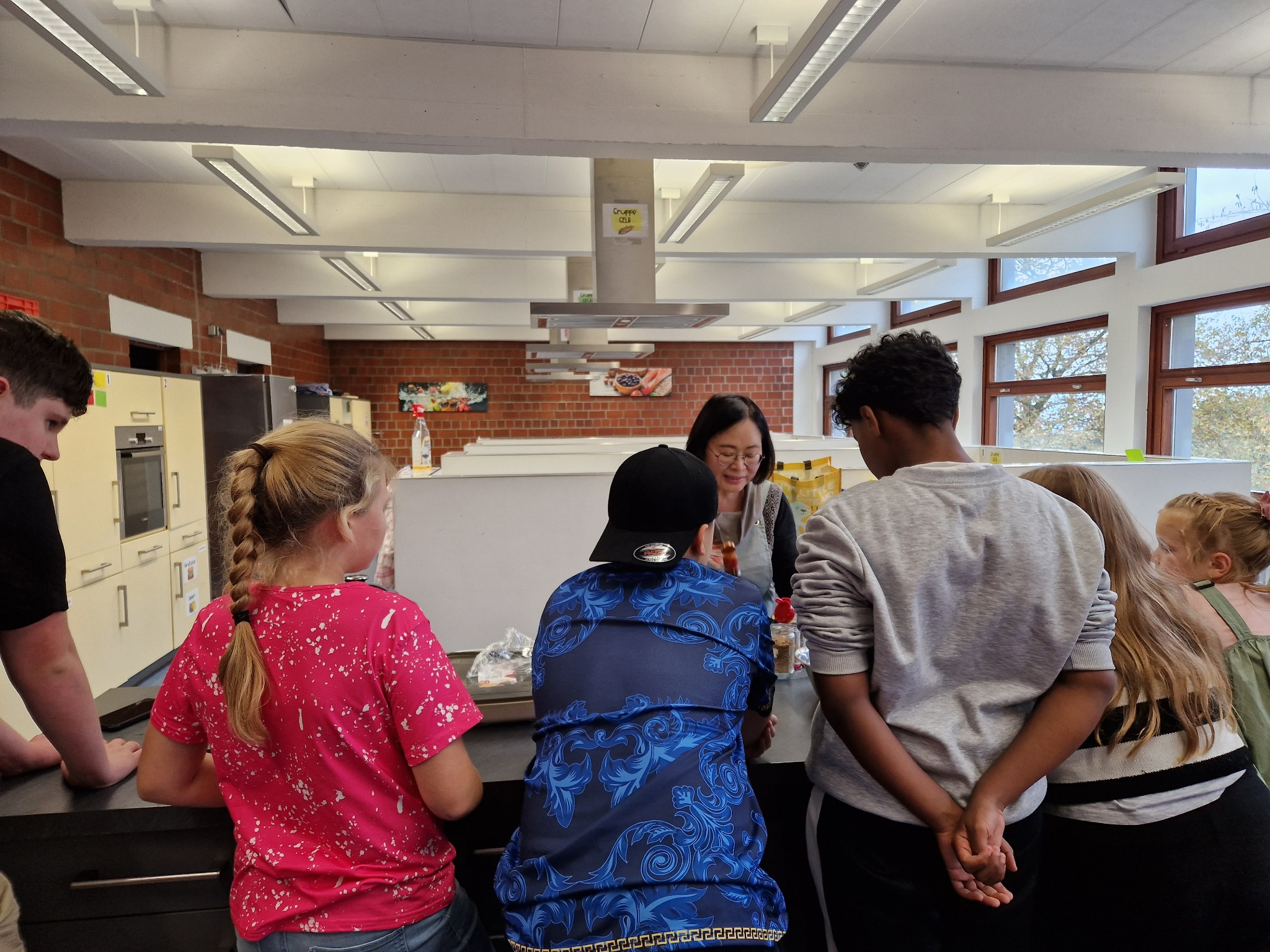 Sungsook Park explains a preparation step to a group of young participants